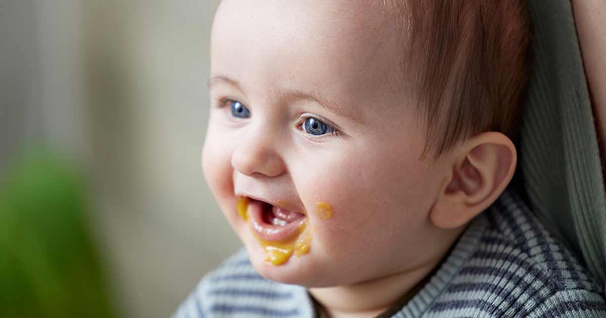 Copil fericit cu mâncare în jurul gurii